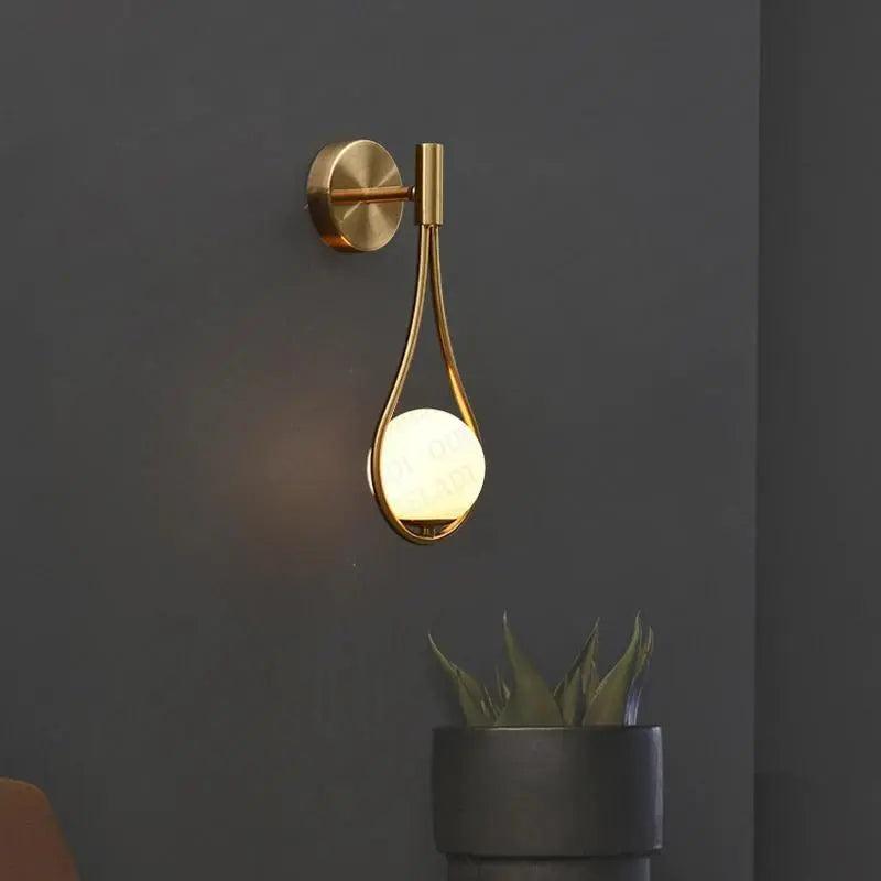 Modern nordisk vägglampa i guld- och svart utförande